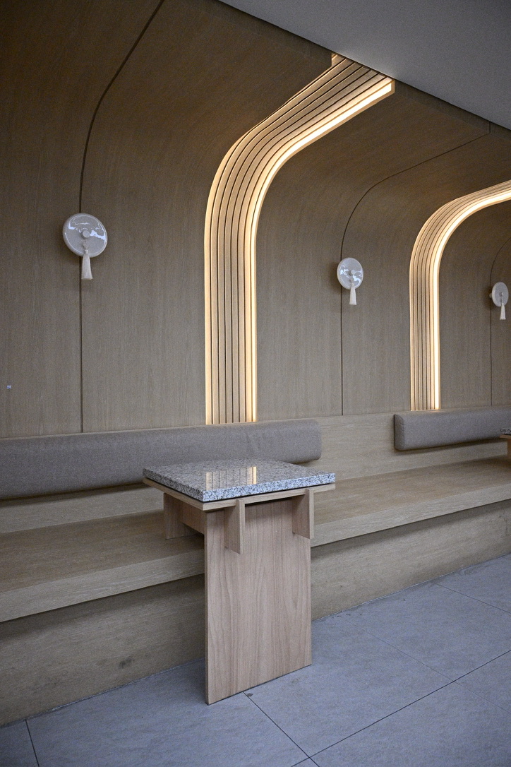 Minimalist wood-paneled interior with arched cove lighting