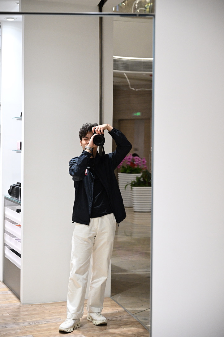 Benedict Ho taking a mirror self-portrait with a camera to his face